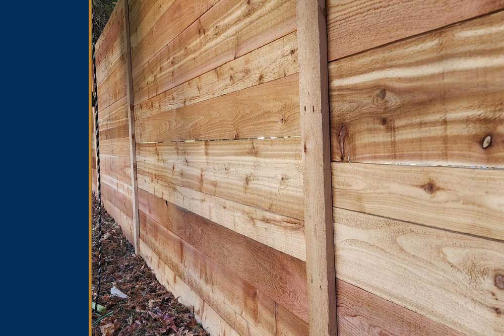 A newly installed wooden fence made from pressure treated lumber, showcasing professional craftsmanship and durable materials, perfect for enhancing outdoor living spaces in Chesapeake.| First In Decks and Fencing | Virginia Beach Deck Builders