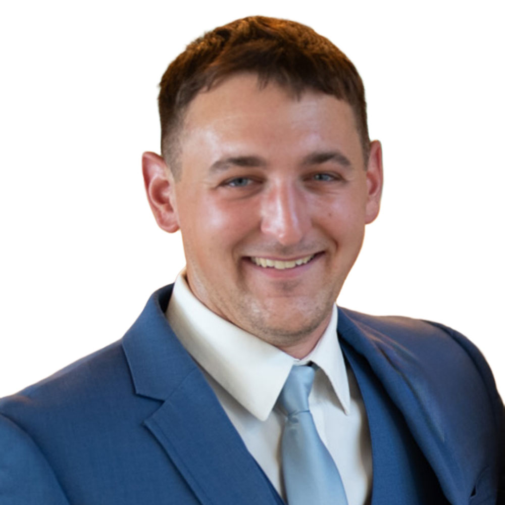 A person in a blue suit and tie smiles, representing dependable service in custom deck and fence installation for outdoor living in Chesapeake, Norfolk, and Virginia Beach.| First In Decks and Fencing | Virginia Beach Deck Builders